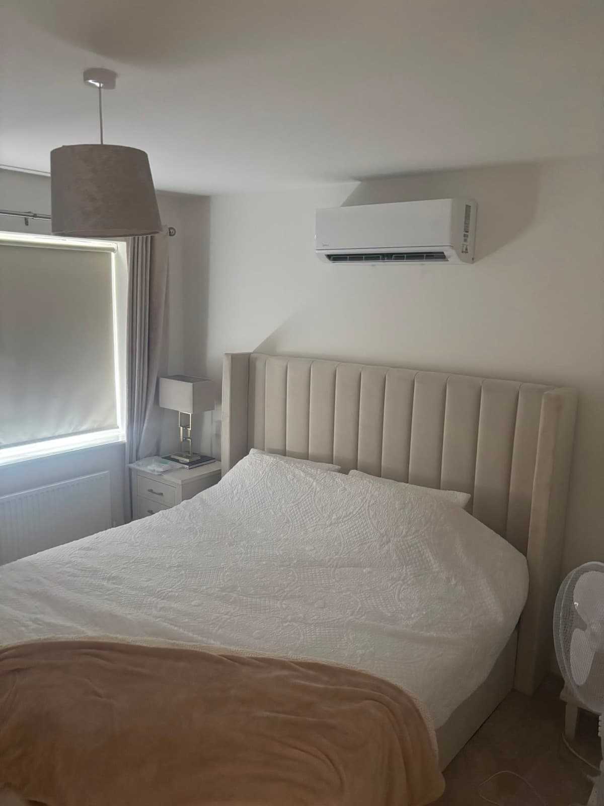 Wall-mounted air conditioning above a bed