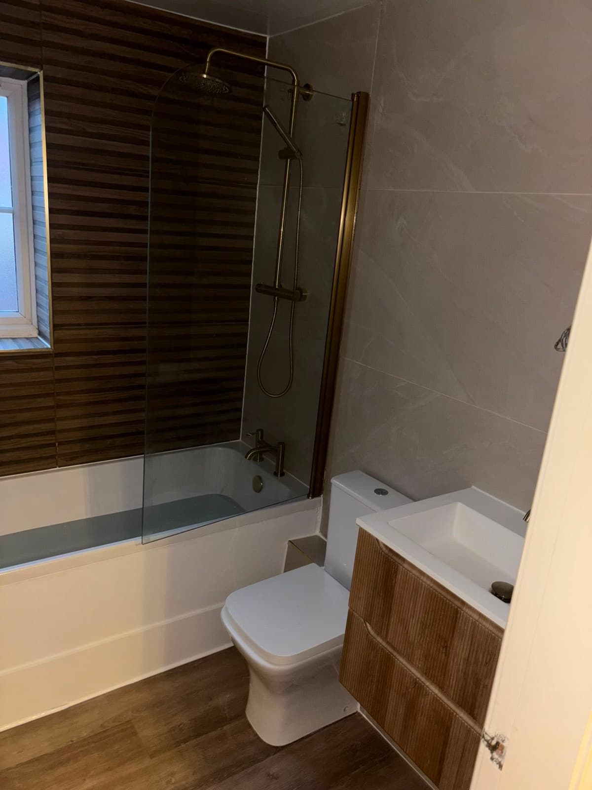 Bathroom with brass shower over the bath