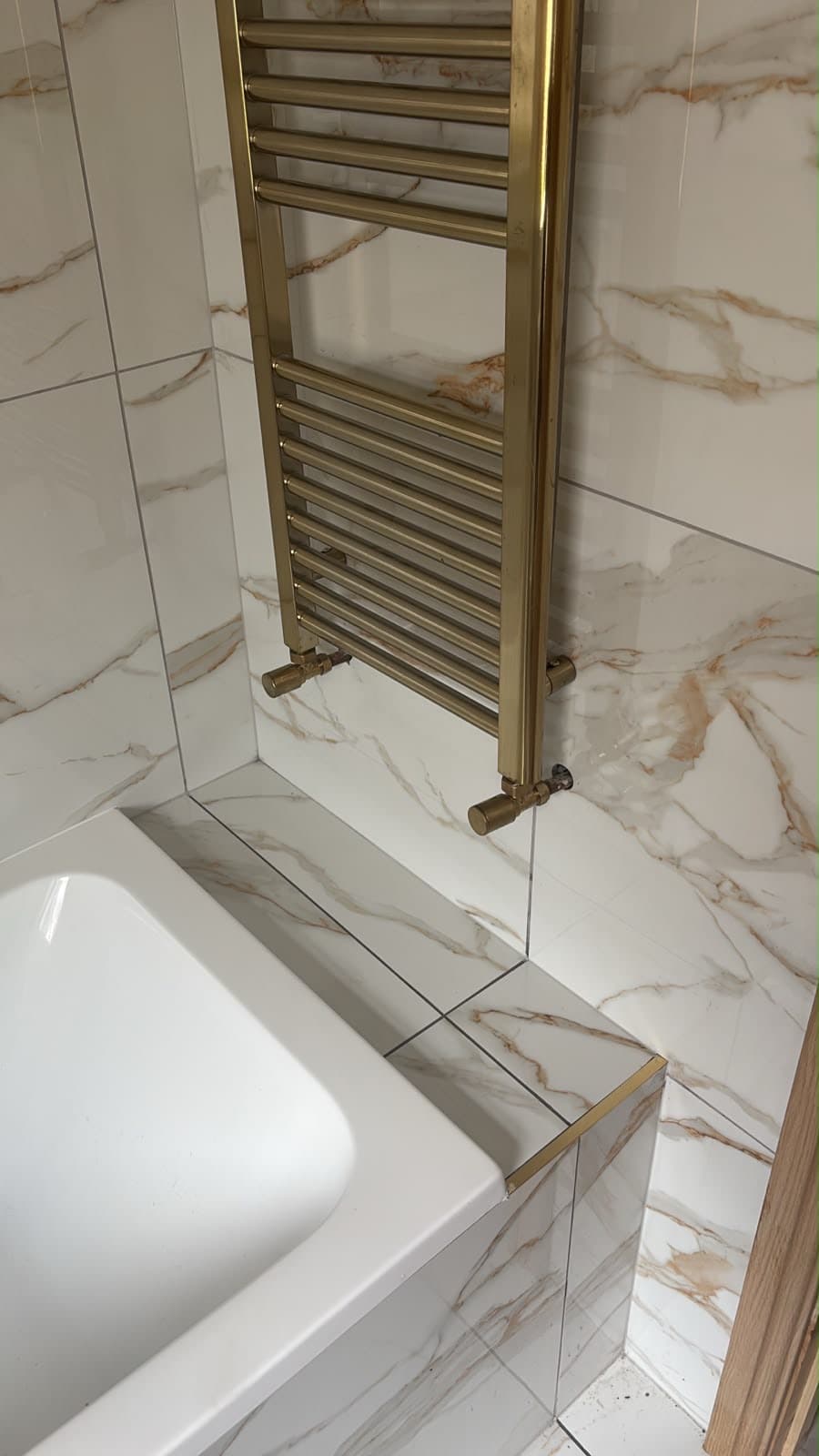 Marble-effect bathroom with a brass heated towel rail