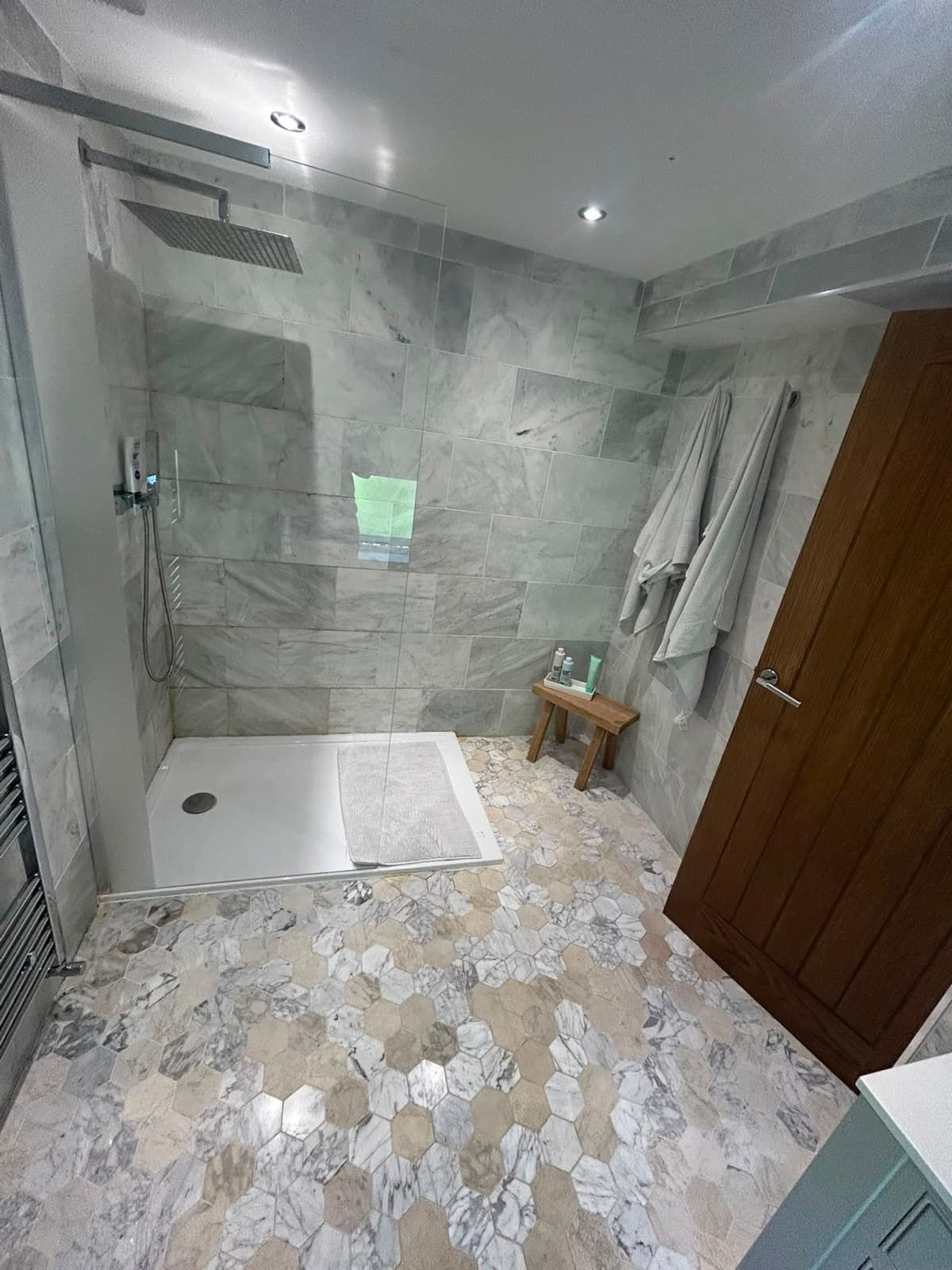 Marble bathroom with a shower over the bath