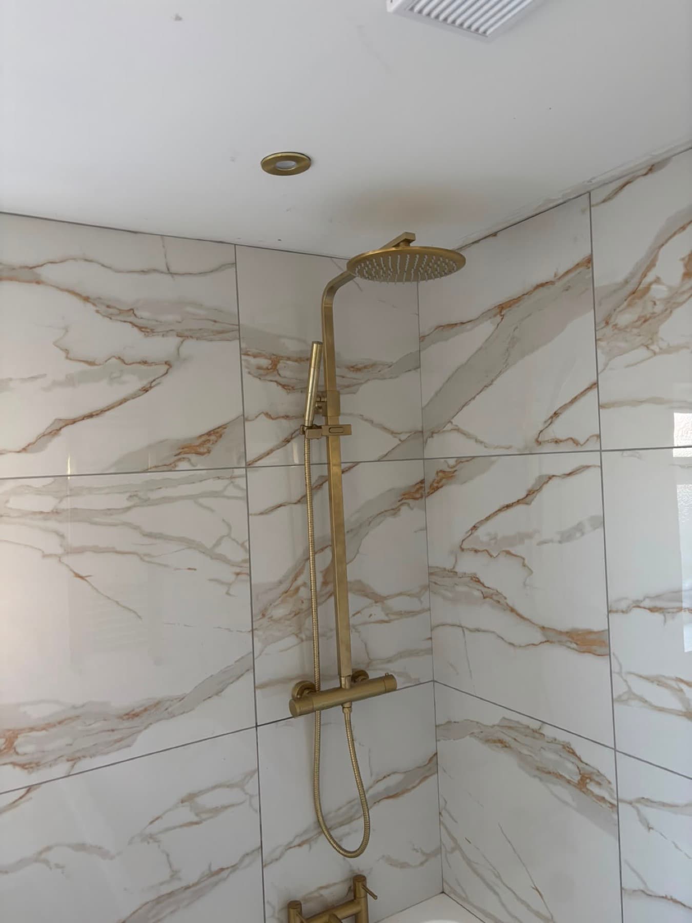 Marble-effect walk-in shower with brass fittings