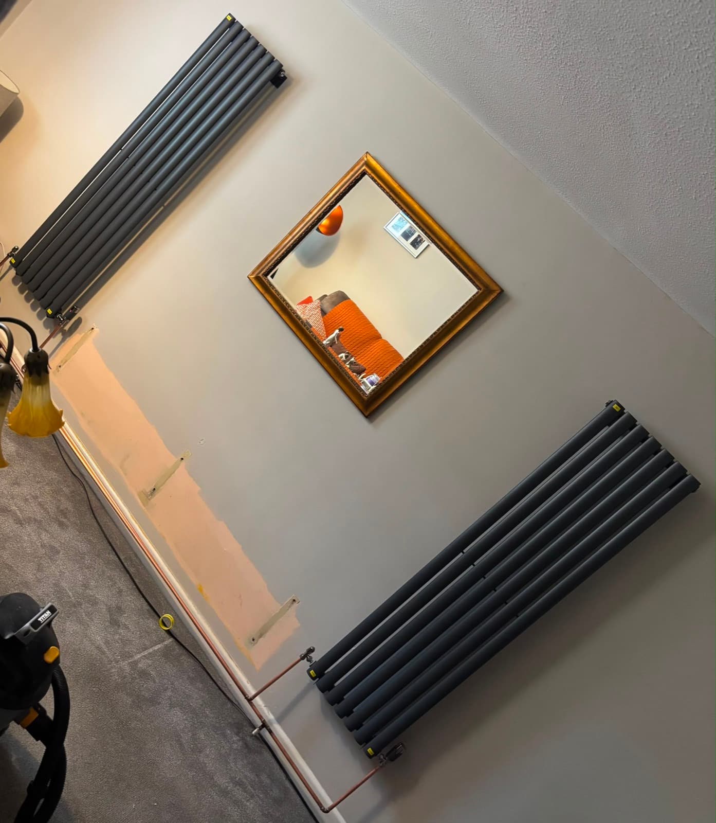 Black vertical radiator in a hallway