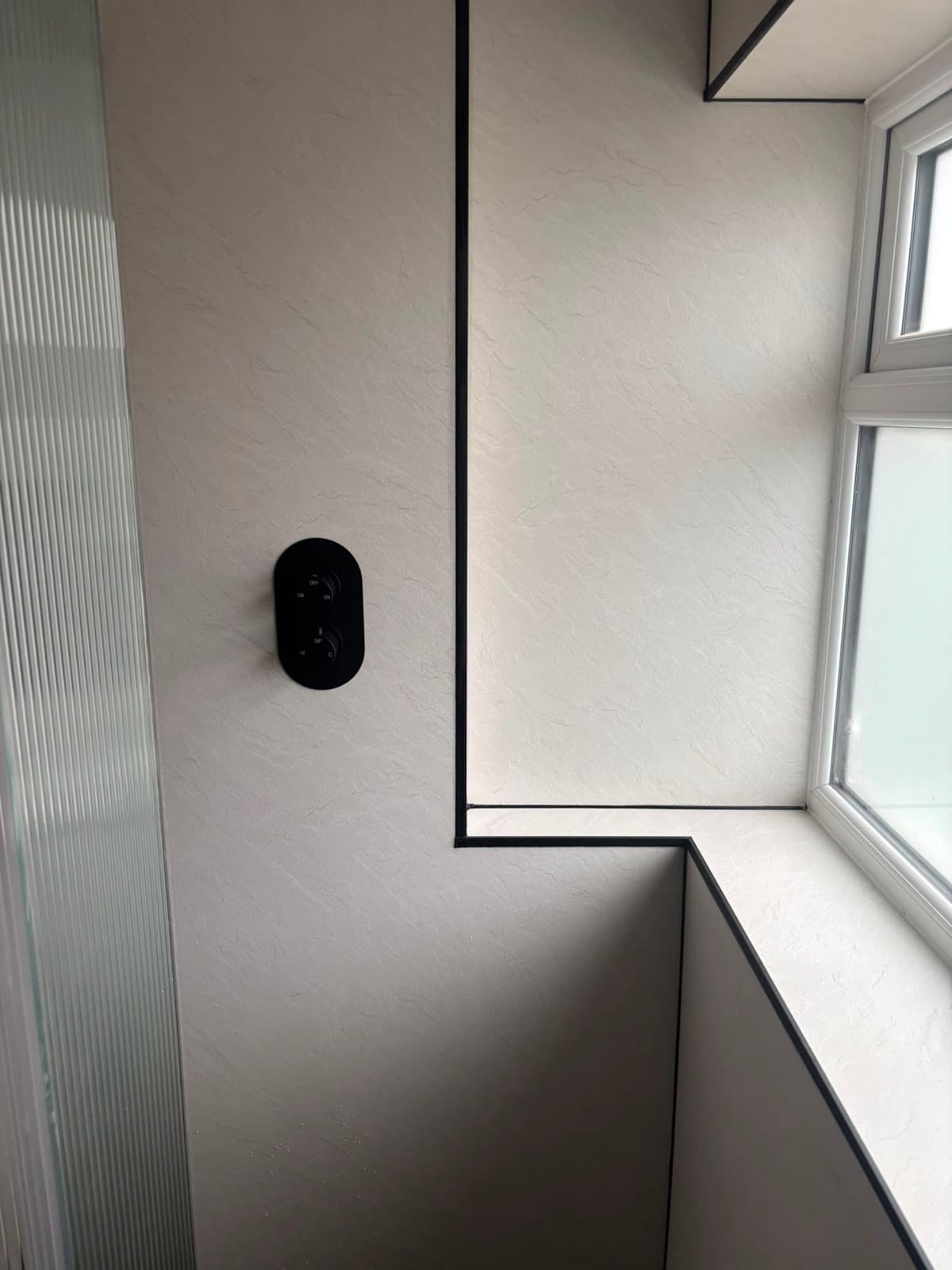 Black shower fittings in a corner