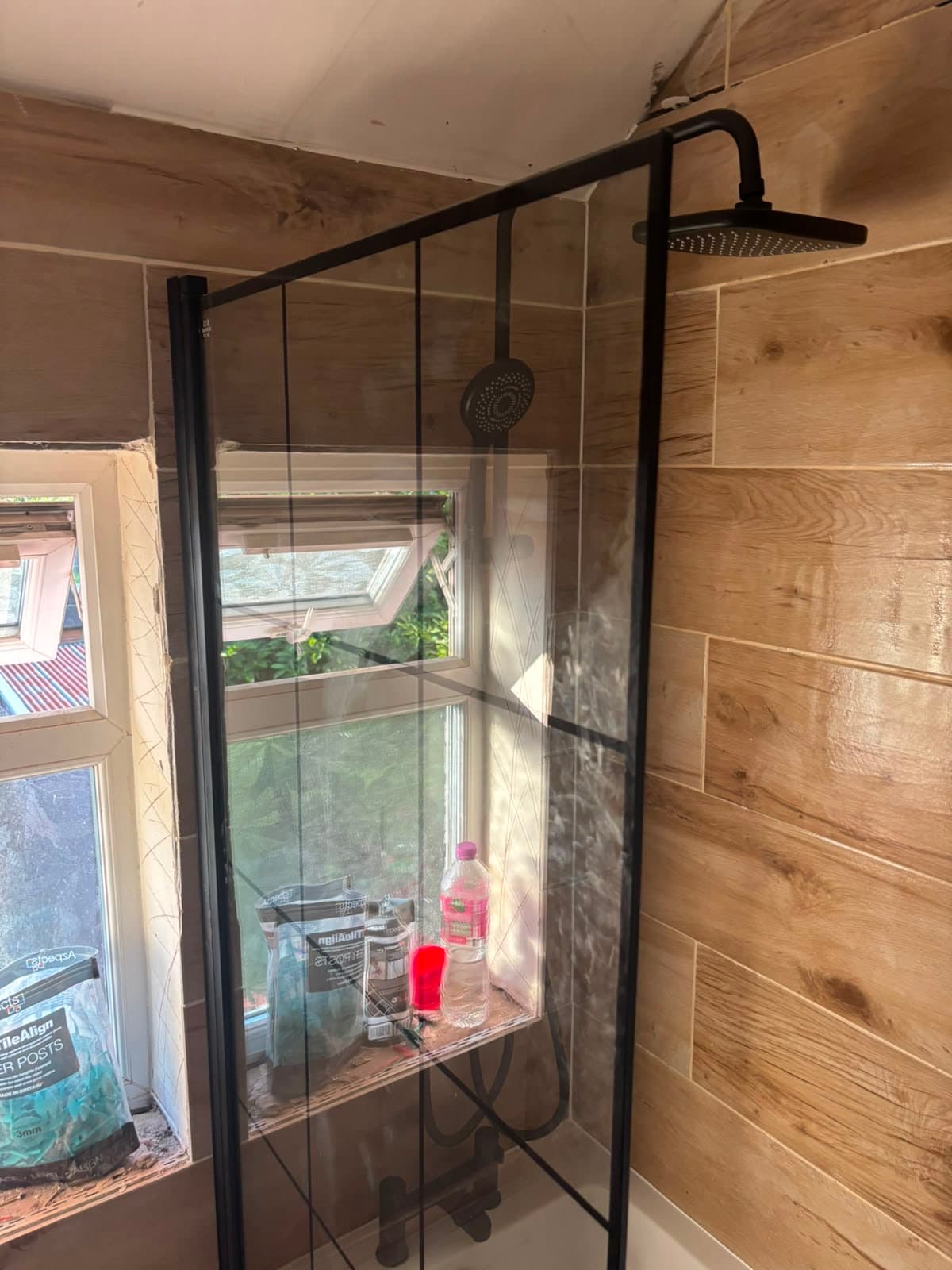 Black shower beside a garden window