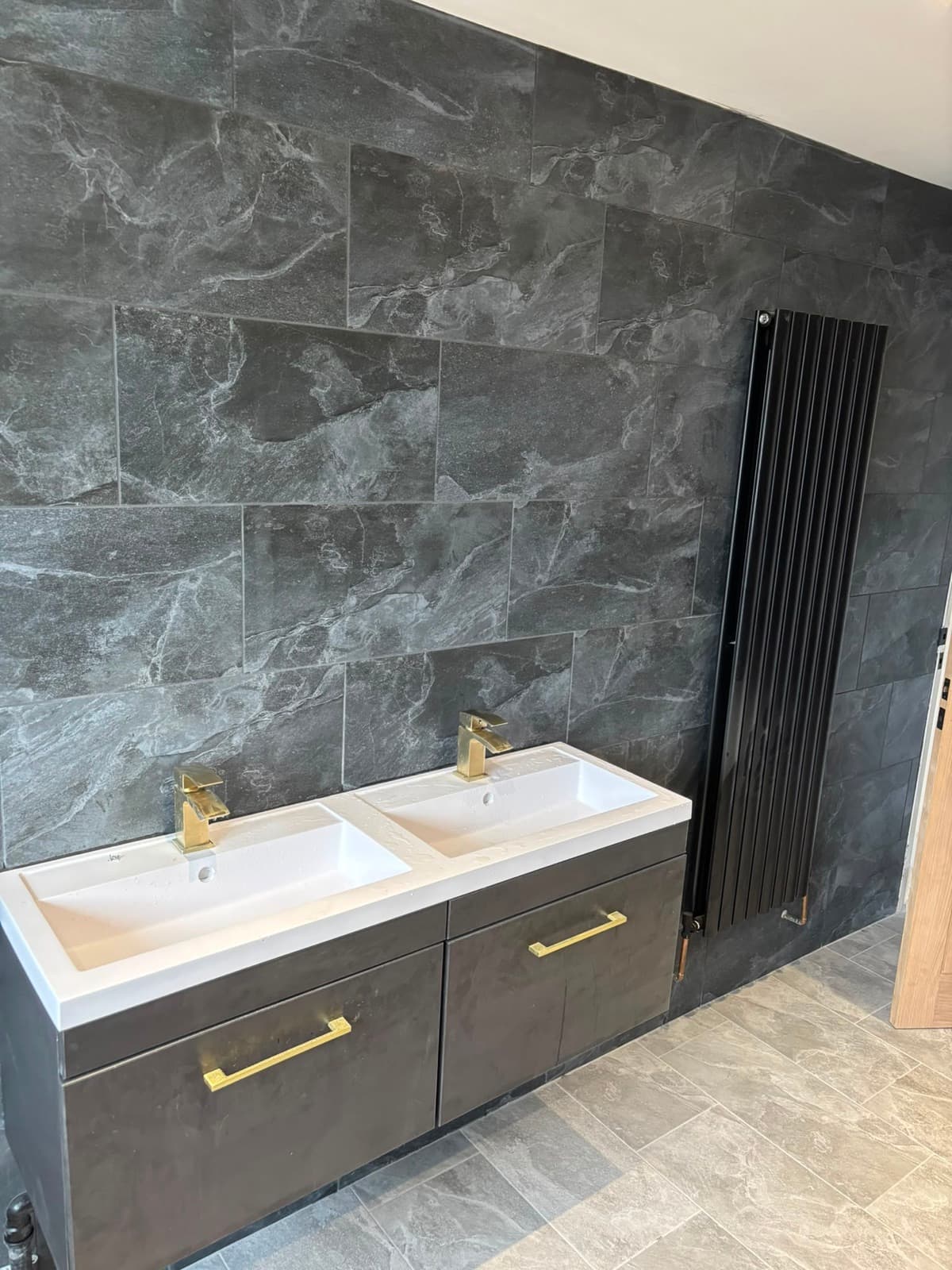 Twin basins with gold taps in a finished bathroom