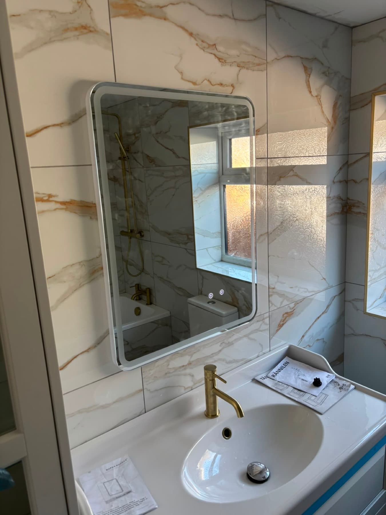 Marble-effect bathroom with brass fittings